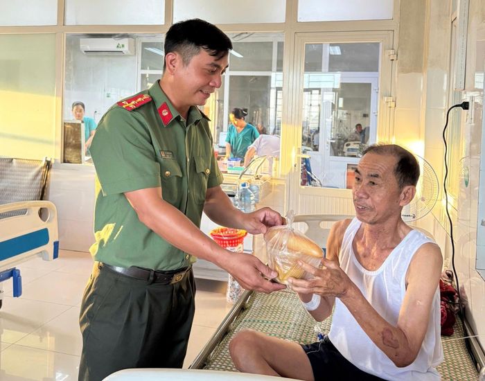 Cán bộ, chiến sĩ Công an phường Điện Bàn trao tặng suất ăn cho bệnh nhân. Ảnh: C.A