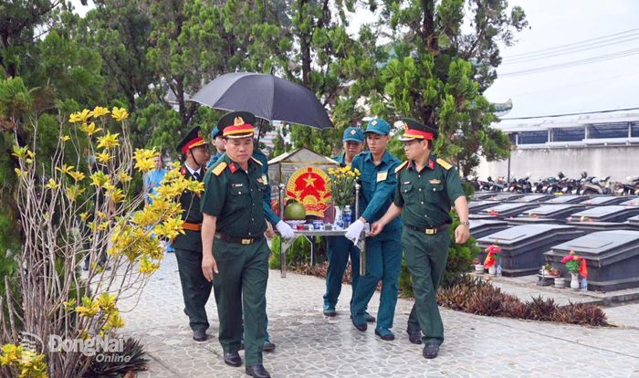 Lực lượng chức năng thực hiện di quách để làm nhiệm vụ lấy mẫu xét nghiệm. Ảnh: Văn Chung