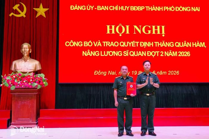 Đại tá Phạm Văn Đảng, Bí thư Đảng ủy, Chính ủy Ban Chỉ huy Bộ đội Biên phòng thành phố Đồng Nai thừa ủy quyền của Bộ Quốc phòng gắn và trao quân hàm thượng tá cho đồng chí Đoàn Văn Định. Ảnh: Tú Trịnh