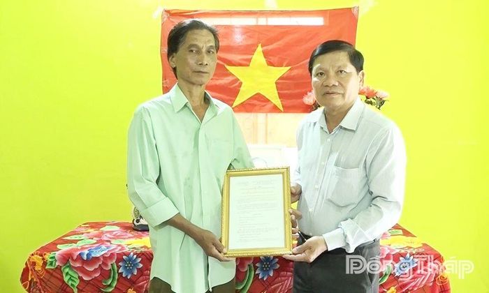 Lãnh đạo xã trao quyết định bàn giao nhà cho ông Nguyễn Văn Bảy (bên trái).