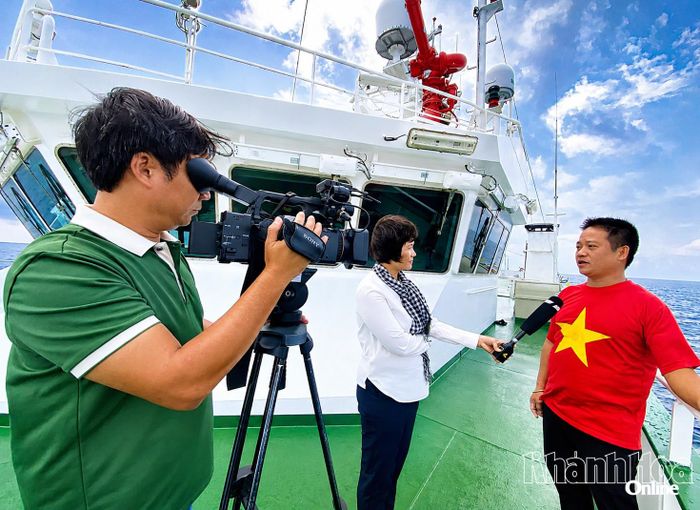 Nhà báo Hoài Nguyệt và Nguyễn Nam (Báo và Phát thanh, Truyền hình Khánh Hòa) tác nghiệp trên tàu KN491 trong chuyến công tác tại đặc khu Trường Sa. Ảnh: VĂN GIANG