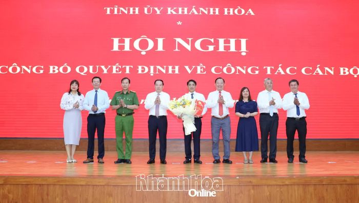 Đồng chí Hồ Xuân Trường trao quyết định và các đại biểu tặng hoa chúc mừng đồng chí Trần Xuân Tây.