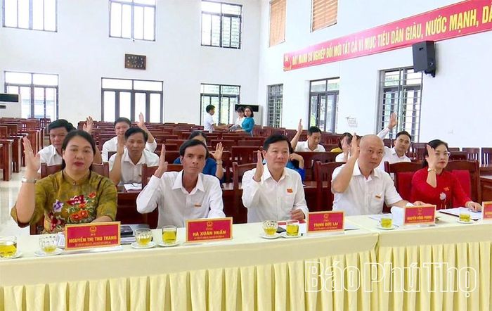 Các đại biểu HĐND xã Bình Phú biểu quyết thông qua các nghị quyết tại kỳ họp.