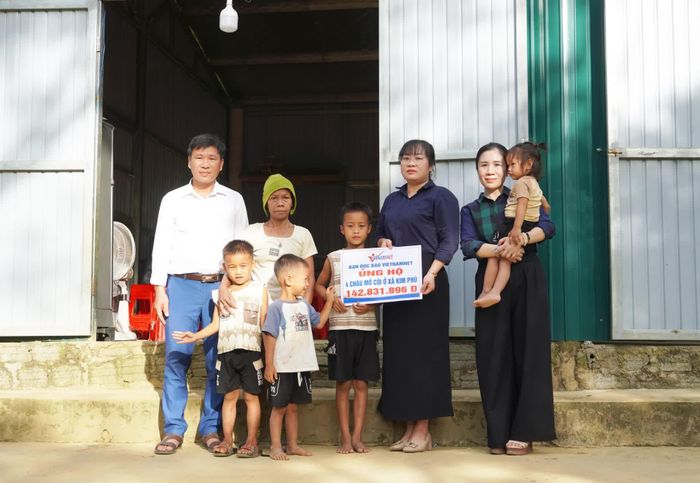 Đại diện Báo VietNamNet trao tiền hỗ trợ 4 trẻ mồ côi ở xã Kim Phú - Ảnh: X.P