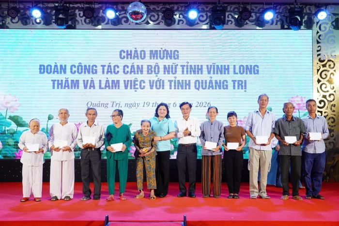 Lãnh đạo tỉnh Vĩnh Long và tỉnh Quảng Trị trao quà cho các gia đình chính sách - Ảnh: N.L