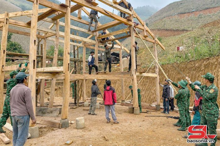 Cán bộ, chiến sĩ Đồn Biên phòng Phiêng Pằn giúp nhân dân dựng nhà.
