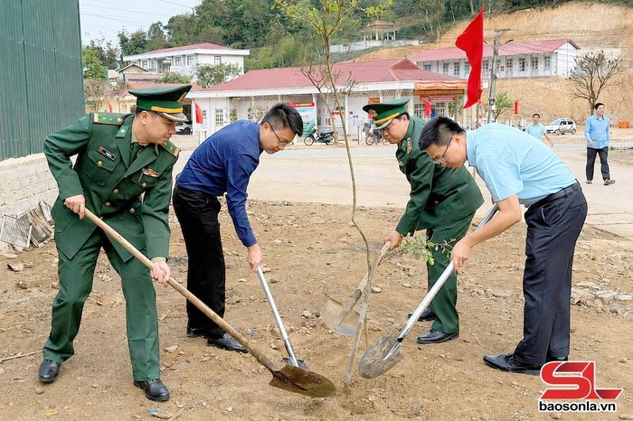 Cán bộ Đồn Biên phòng Phiêng Pằn cùng lãnh đạo xã Phiêng Pằn trồng cây xanh dọc tuyến giao thông.