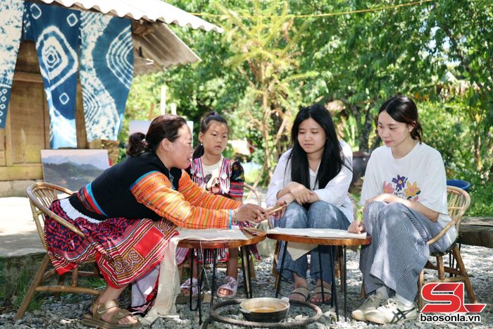 Không gian Vườn Đào mời bà con dân tộc Mông hướng dẫn du khách trải nghiệm thêu hoa văn trên vải.