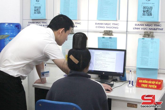Cán bộ Trung tâm Phục vụ hành chính công phường Chiềng Sinh hỗ trợ người dân kê khai hồ sơ điện tử.