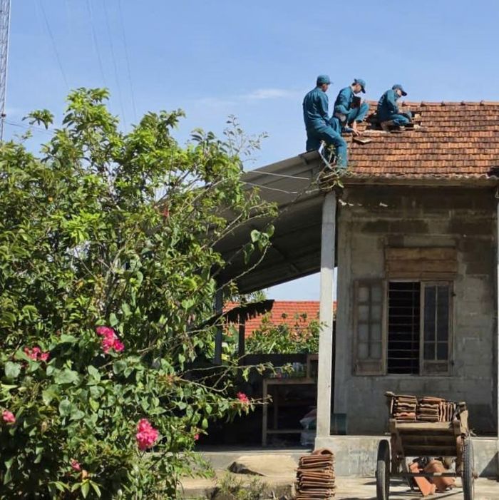 Các lực lượng phường Hương Trà giúp dân sửa chữa lại mái nhà do dông, lốc. Ảnh: V.Nhân