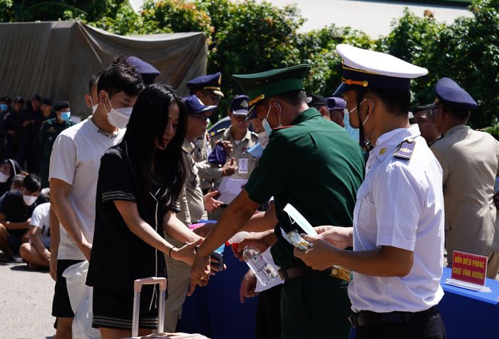 Các cơ quan chức năng kiểm tra thân nhiệt, sát khuẩn, phát khẩu trang cho công dân trước khi trở về nước. Ảnh: Tiến Vinh
