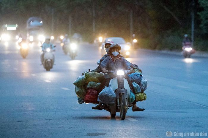 Đường gom Đại lộ Thăng Long lúc 4h sáng (đoạn qua phường Đại Mỗ), nhiều tiểu thương đã chất đầy hàng hóa trên xe máy, nối đuôi nhau di chuyển từ các xã ngoại thành vào trung tâm thành phố.