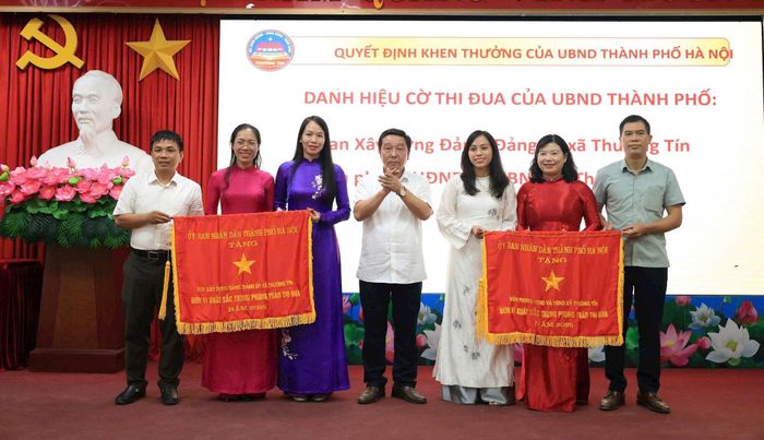 Hai tập thể của xã Thường Tín nhận cờ thi đua của UBND thành phố Hà Nội. Ảnh: PV