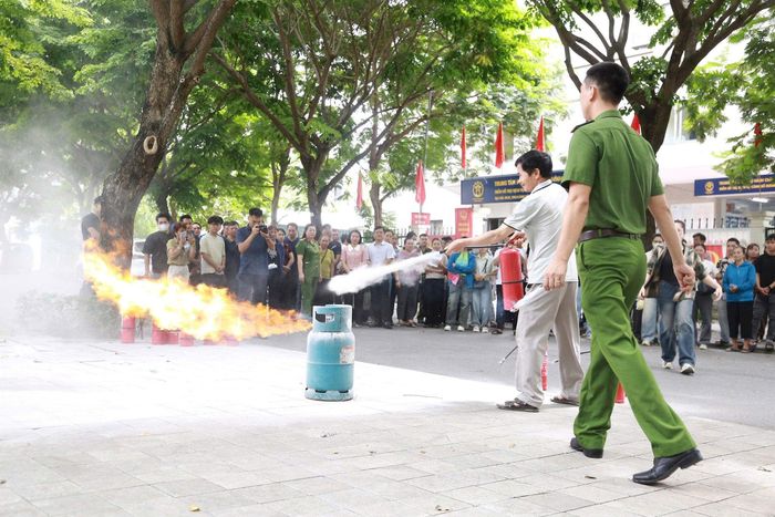 Các đại biểu được hướng dẫn thực hành sử dụng thiết bị chữa cháy. Ảnh: Thu Oanh