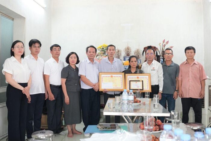 Trao tặng Bằng khen, kỷ niệm chương cho gia đình ông Vũ Minh Hiếu. Ảnh: CDC Quảng Ninh.