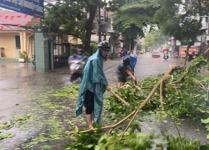 Lực lượng chức năng thu dọn cành cây gãy đổ tại phường Thuận Hóa. Ảnh: TT