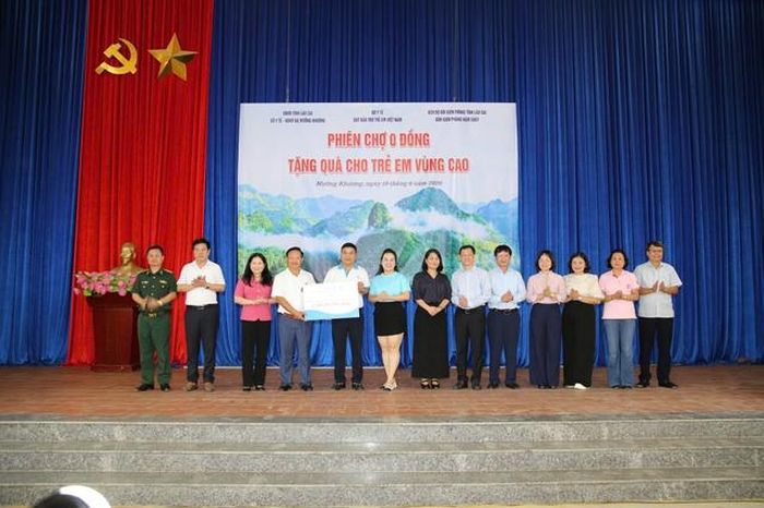 Các đồng chí lãnh đạo Quỹ Bảo trợ trẻ em Việt Nam trao trao biển tượng trưng số tiền gần 2,4 tỷ đồng quà tặng thông qua Phiên chợ cho lãnh đạo xã Mường Khương. Các đại biểu là lãnh đạo thuộc các tổ chức ở Trung ương và lãnh đạo tỉnh Lào Cai chứng kiến.