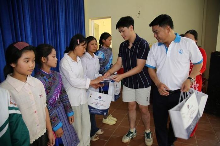 Ông Đinh Tiến Hải - Giám đốc Quỹ Bảo trợ trẻ em Việt Nam và em Nguyễn Huỳnh Nghị tặng quà và học bổng cho trẻ em có hoàn cảnh đặc biệt, khó khăn xã Mường Khương, tỉnh Lào Cai.
