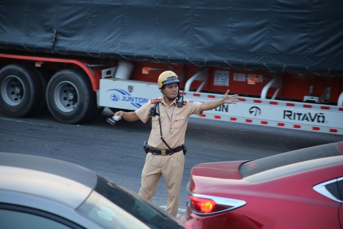  CSGT có mặt tại các nút giao trọng điểm để điều tiết giao thông, hướng dẫn người dân lựa chọn lộ trình phù hợp nhằm giảm áp lực cho tuyến Quốc lộ 1. Ảnh: PHẠM HẢI 