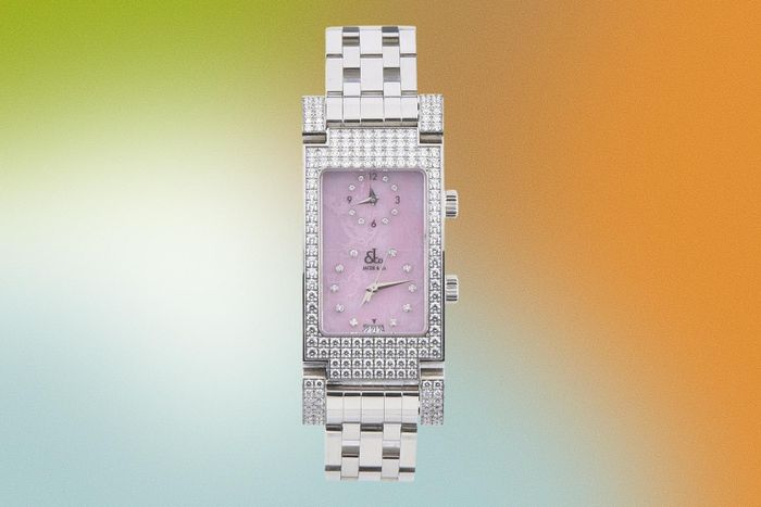  Thiết kế này có vỏ và dây bằng thép nạm kim cương, mặt số màu hồng, cọc số kim cương và chức năng Dual Time, cho phép hiển thị hai múi giờ cùng lúc. Mẫu đồng hồ của nữ influencer còn có ô lịch ngày ở vị trí 6 giờ và sử dụng bộ máy quartz. Hiện sản phẩm không còn được phân phối trên kênh chính thức của thương hiệu. Ảnh: eBay.