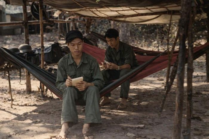 Phóng viên Vũ Xuân Bân ngồi võng dù trên chiến trường bảo vệ biên giới Tây Nam cuối năm 1978