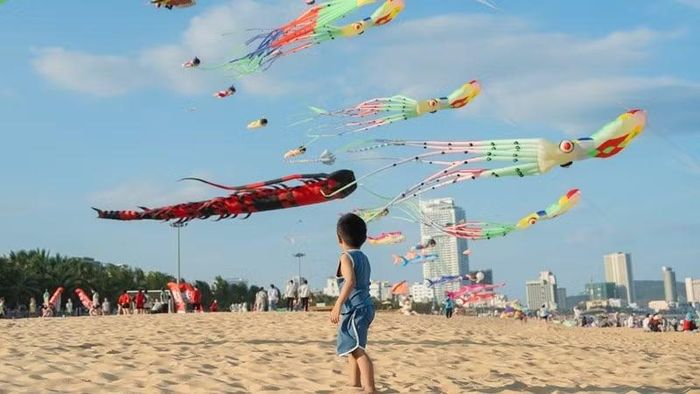 Các em nhỏ thích thú theo dõi màn thi diều đồng đội hoành tráng tại bãi biển Xuân Diệu.