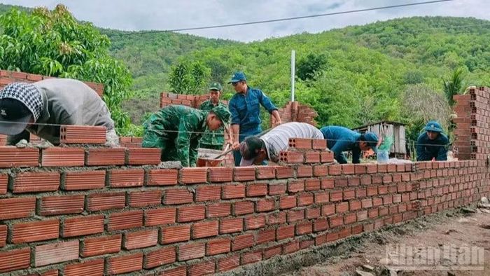 Các chiến sĩ Đồn Biên phòng Vĩnh Hải cùng dân quân địa phương xây nhà mới cho các gia đình được hỗ trợ, không chỉ giúp nơi trú ngụ an toàn trước nắng mưa mà còn là nguồn động viên lớn lao, tiếp thêm niềm tin để người dân vượt qua khó khăn, ổn định cuộc sống. (Ảnh: NGUYỄN TRUNG)