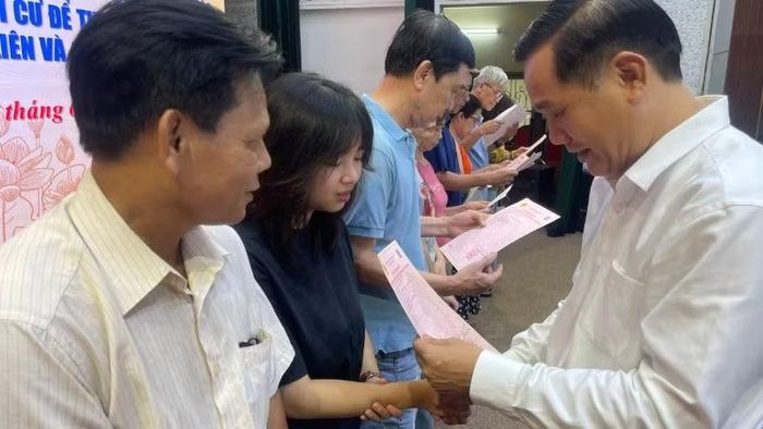 Chủ tịch Ủy ban nhân dân xã Thư Lâm trao giấy chứng nhận quyền sử dụng đất cho người dân.