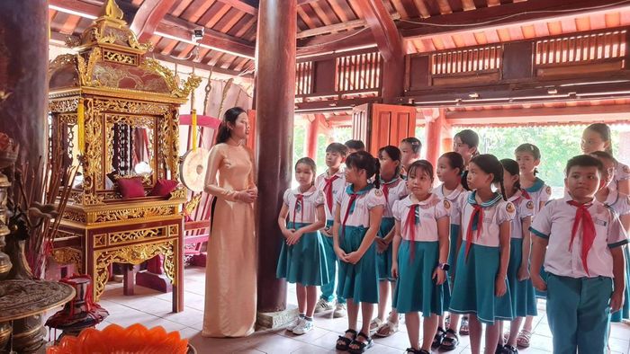 Học sinh xã Sơn Cẩm Hà được nghe cô giáo giới thiệu về lịch sử Đình làng Hội An.
