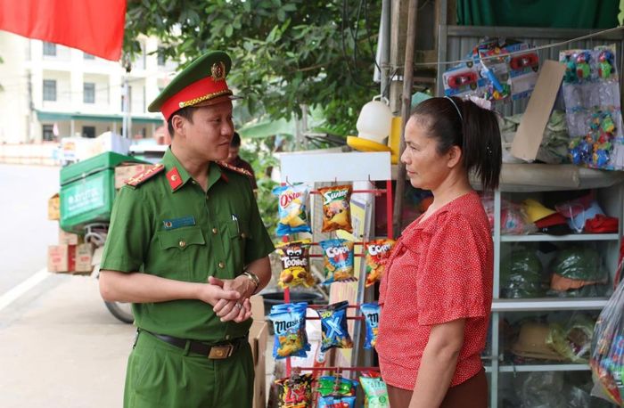 Đại úy Nguyễn Kim Nghĩa đang tuyên truyền với người dân về vấn đề chấp hành hành lang ATGT.