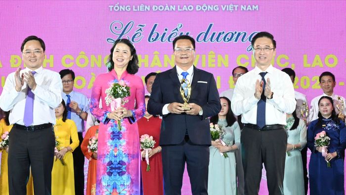 Chủ tịch Tổng LĐLĐ Việt Nam Nguyễn Anh Tuấn và Phó Bí thư Thành ủy TPHCM Đặng Minh Thông chúc mừng các gia đình được biểu dương. Ảnh: VIỆT DŨNG