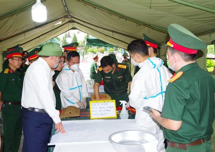 Lực lượng chức năng lấy mẫu sinh phẩm hài cốt liệt sĩ tại Nghĩa trang liệt sĩ Nghi Lộc.