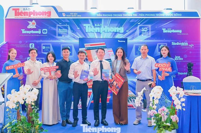 Tổng Biên tập Báo Tiền Phong Phùng Công Sưởng (đứng giữa) cùng TS Ngô Bích Ngọc, Trưởng khoa Truyền thông đa phương tiện, Đại học Swinburne Việt Nam (thứ ba từ phải sang) tại gian trưng bày báo Tiền Phong ngày 20/6.