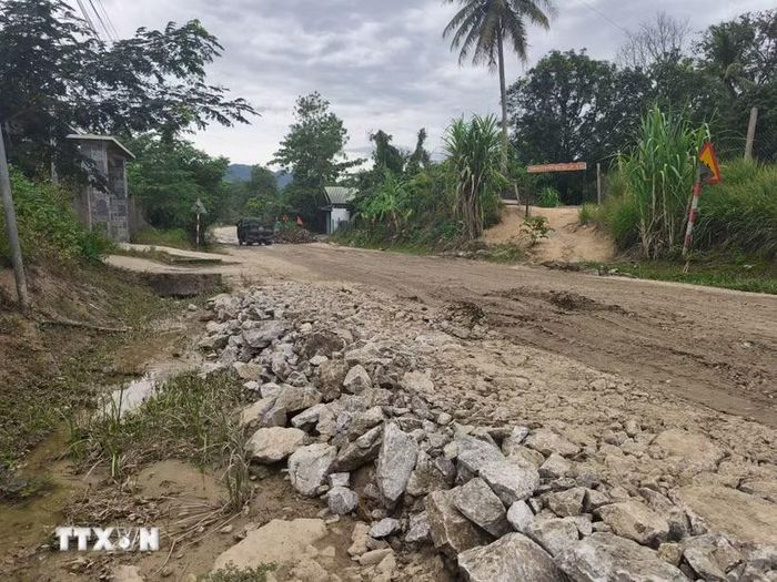 Người dân hàng ngày phải đi qua tuyến đường đầy bùn đất, đá hộc. (Ảnh: Quốc Dũng/TTXVN)