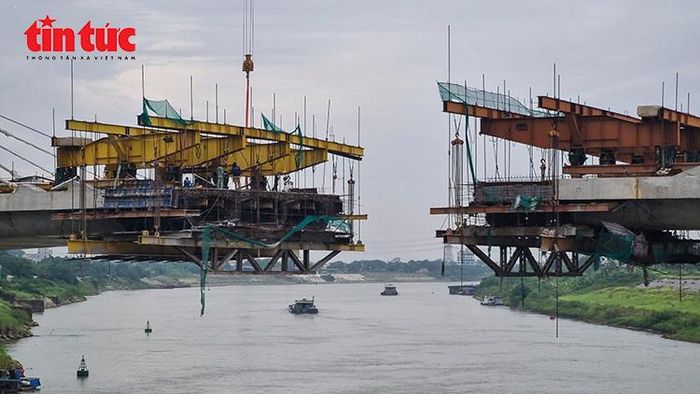 Các nhịp cầu Đuống mới đang được hợp long từng bước, bảo đảm tĩnh không thông tàu thuyền.