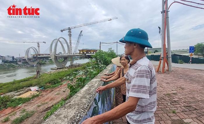 Người dân sống ven sông Đuống theo dõi quá trình thi công cầu mới, công trình được kỳ vọng thay đổi diện mạo giao thông khu vực.