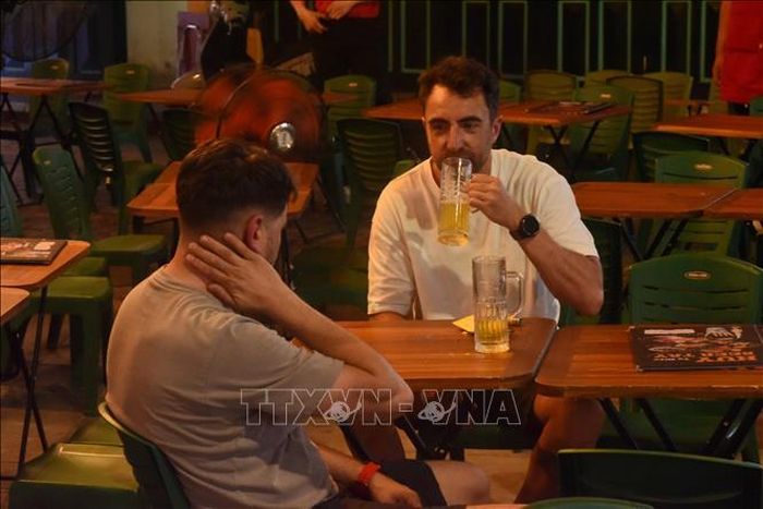 Du khách thưởng thức bia trên phố Tạ Hiện (Hà Nội). Ảnh: Tuyết Mai/TTXVN