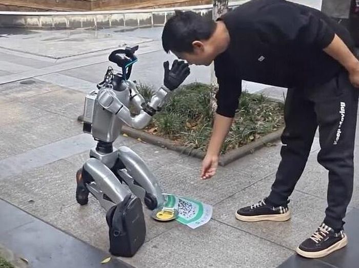Robot hình người xuất hiện trên một tuyến phố ở tỉnh Tứ Xuyên (Trung Quốc), bên cạnh là bảng đèn LED và loa phát thanh thông báo. Ảnh: Jam Press