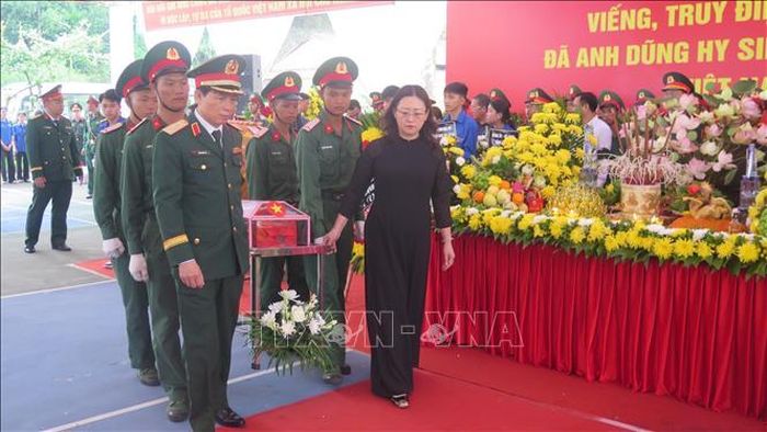 Các đại biểu thực hiện di quan đến khu vực an táng hài cốt liệt sĩ.
