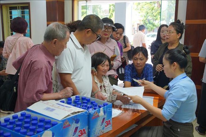 Người dân kiểm tra thông tin được ghi trong Giấy chứng nhận quyền sử dụng đất. Ảnh: Kim Anh/TTXVN