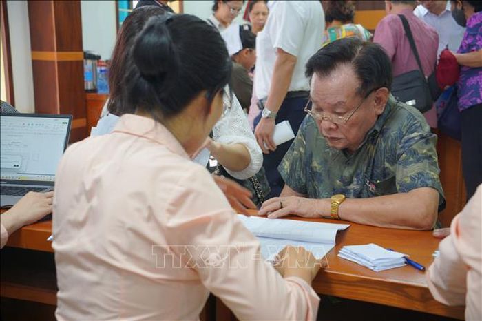 Người dân đối chiếu thông tin trong danh sách cấp Giấy chứng nhận quyền sử dụng đất. Ảnh: Kim Anh/TTXVN