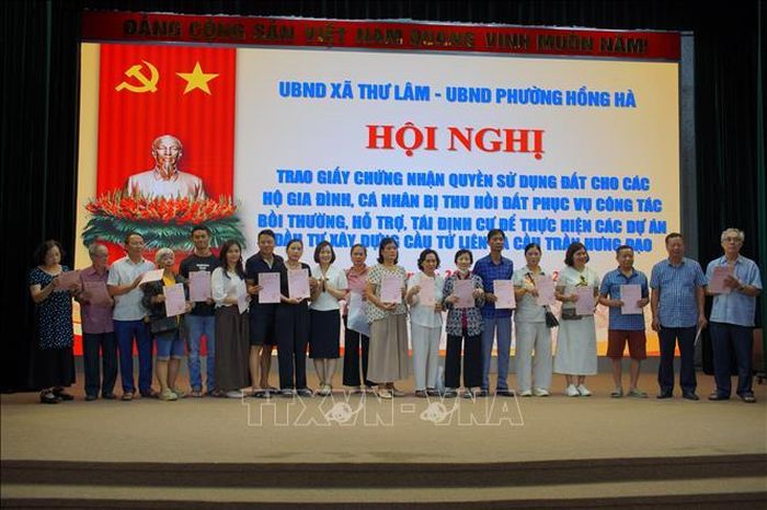 Người dân nhận Giấy chứng nhận quyền sử dụng đất. Ảnh: Kim Anh/TTXVN