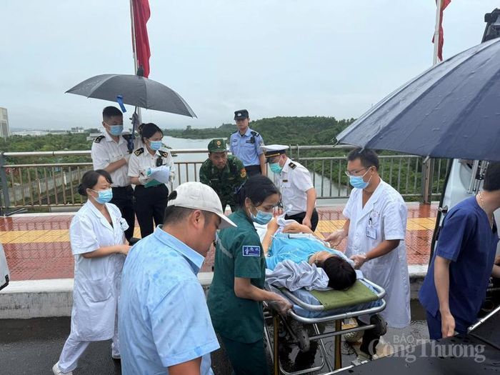 Chiến sĩ Đồn Biên phòng Cửa khẩu quốc tế Móng Cái phối hợp với đội ngũ y tế Trung Quốc bàn giao bệnh nhân ngay tại vạch phân định hai nước.