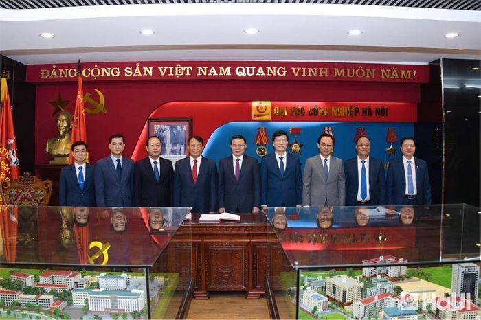 Bộ trưởng Bộ Công Thương Lê Mạnh Hùng và Bộ trưởng Bộ Giáo dục và Đào tạo Hoàng Minh Sơn ghi lưu bút tại Sổ vàng truyền thống của Đại học Công nghiệp Hà Nội. 