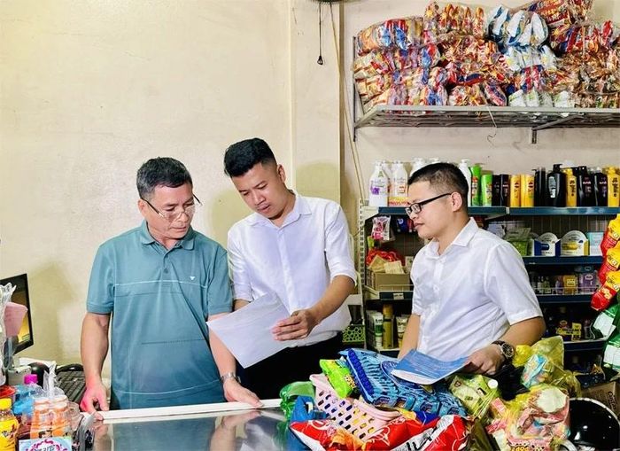 Cán bộ BHXH cơ sở Quan Sơn hướng dẫn người dân đăng ký nhận lương hưu qua tài khoản ngân hàng.