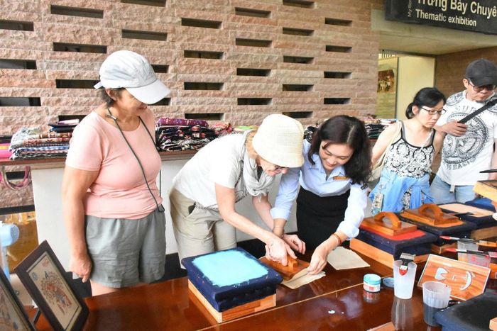 Du khách trải nghiệm in tranh trên giấy tại Khu đền tháp Mỹ Sơn. Ảnh: ĐVCC