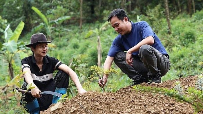 Ông Nguyễn Thanh Bình (bên phải) trồng cây tại dự án "Rừng bách thảo" của mình. Ảnh: NAM PHƯỚC