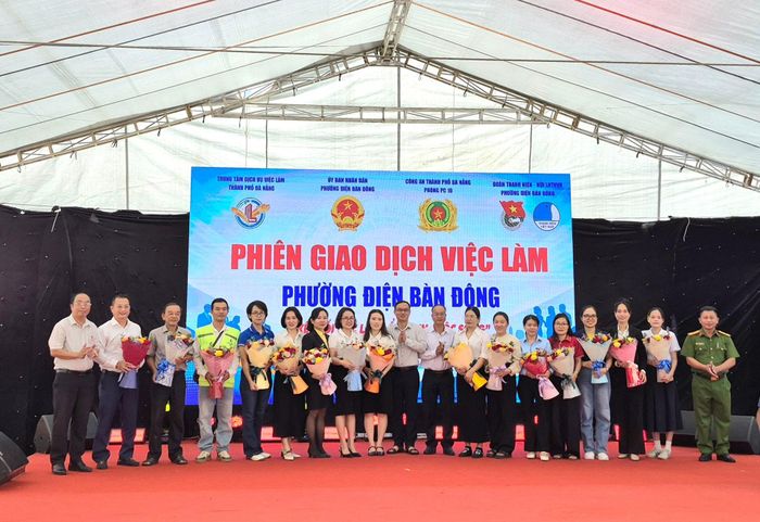 Ban tổ chức tặng hoa cho đại diện các doanh nghiệp tham gia phiên giao dịch việc làm. Ảnh: QUỐC TUẤN