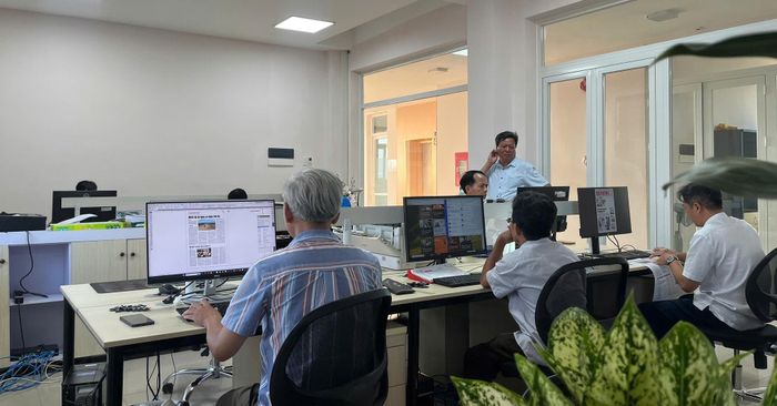 Những người phía sau trang báo. Ảnh: X.H