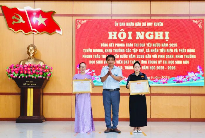 Lãnh đạo xã Duy Xuyên trao danh hiệu Chiến sĩ thi đua cấp thành phố cho 2 giáo viên. Ảnh: QUỐC TUẤN